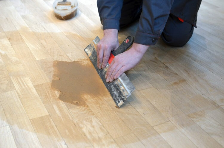 applying putty to wooden floors